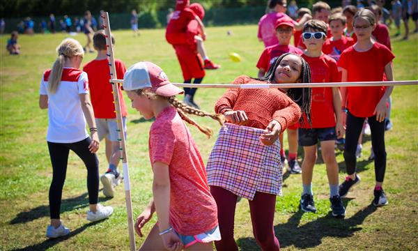 Students limbo under a pole